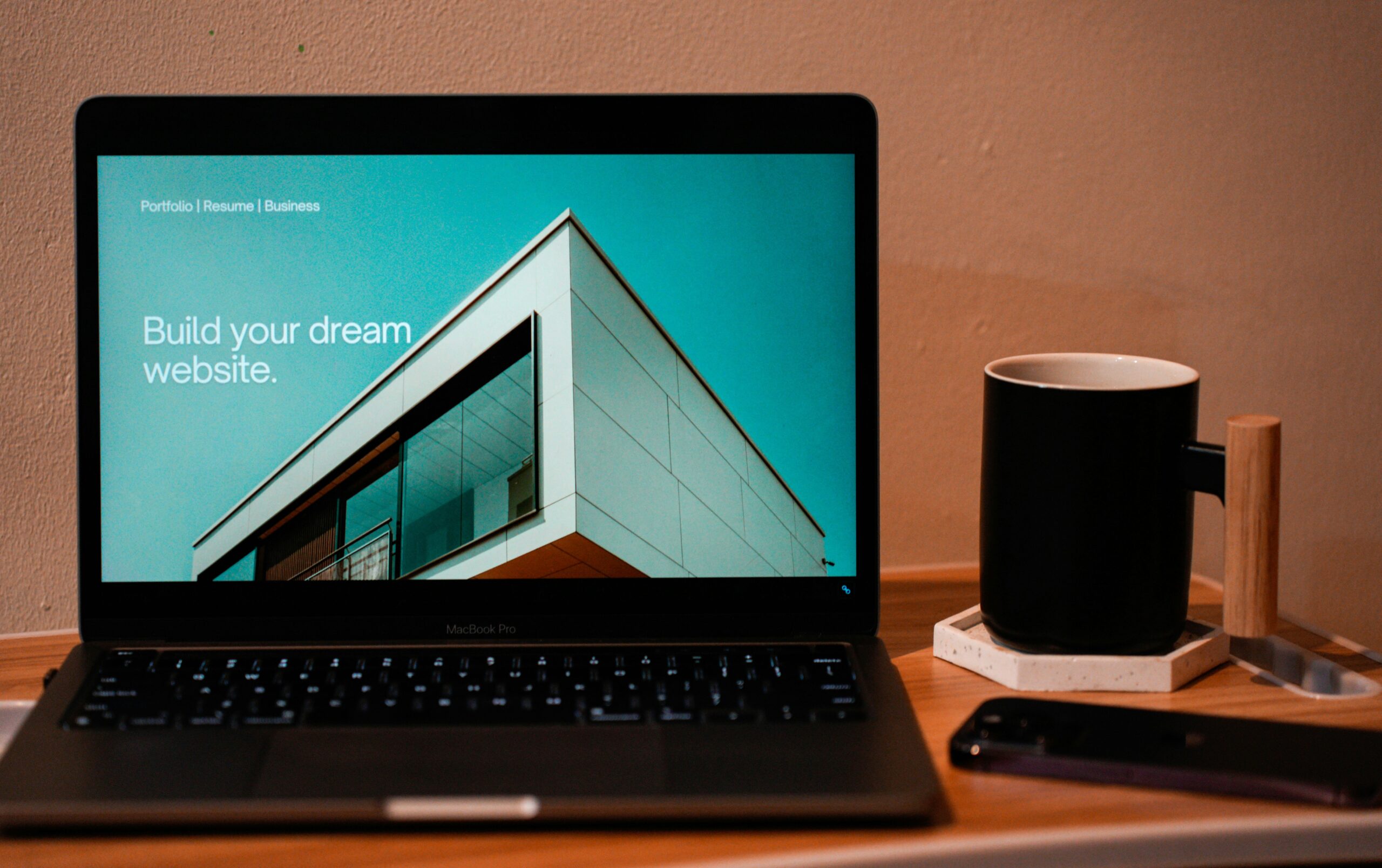 open laptop next to coffee cup, the website says "build your dream website"; build your dream website with New Southern Solutions, experts in web design, e-commerce, SEO, progressive web apps, and digital solutions.